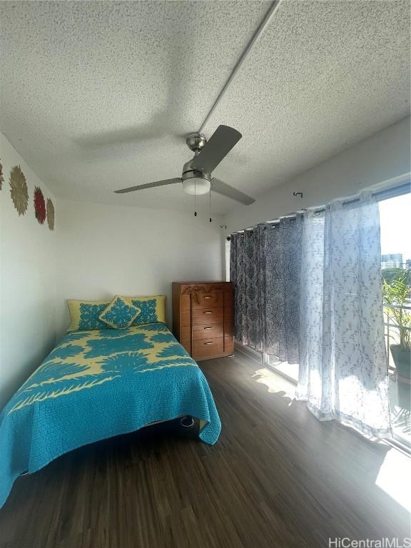 bedroom featuring a textured ceiling, ceiling fan, and dark hardwood / wood-style flooring