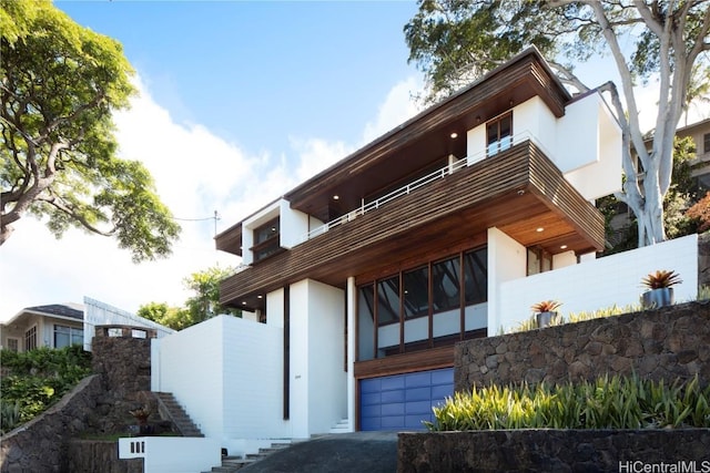 exterior space with a garage and a balcony