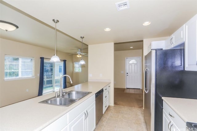 kitchen featuring pendant lighting, sink, light tile patterned floors, stainless steel appliances, and white cabinets