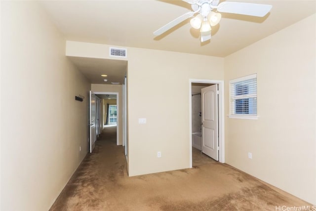 unfurnished bedroom with carpet flooring, ceiling fan, and a spacious closet