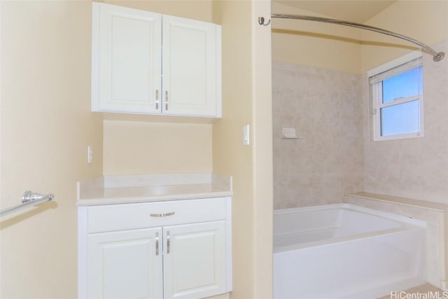 bathroom featuring tiled shower / bath combo and vanity