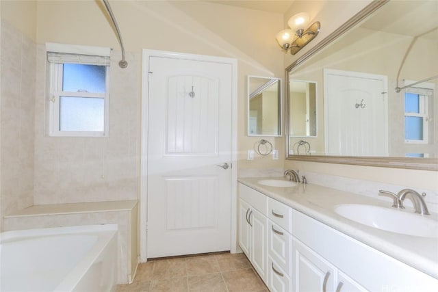 bathroom featuring a bathing tub, tile patterned floors, and vanity