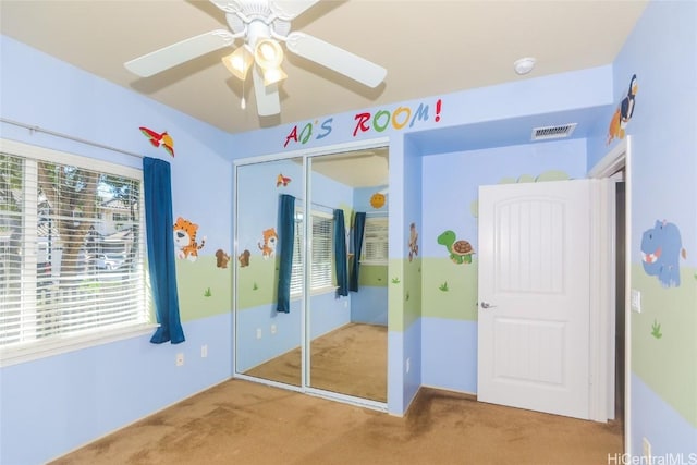 unfurnished bedroom featuring ceiling fan, carpet, and a closet