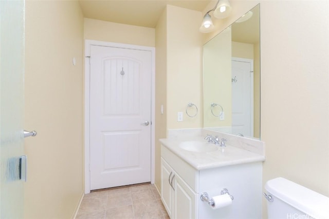 bathroom featuring tile patterned flooring, vanity, and toilet