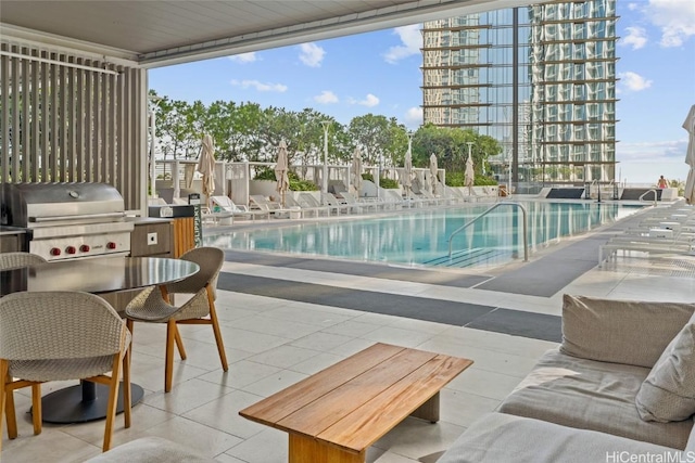 view of pool featuring grilling area and a patio