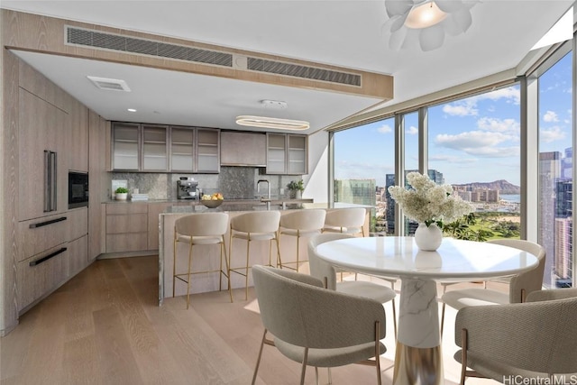 dining area with ceiling fan, a wealth of natural light, and light hardwood / wood-style flooring