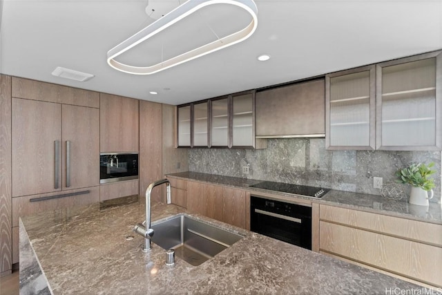 kitchen with sink, backsplash, black appliances, and dark stone counters