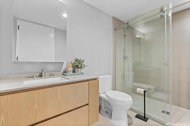 bathroom featuring a shower with door, vanity, and toilet