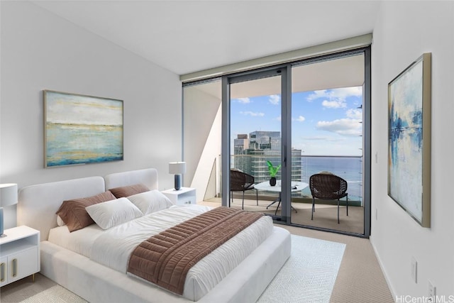 carpeted bedroom featuring access to exterior, a water view, and expansive windows