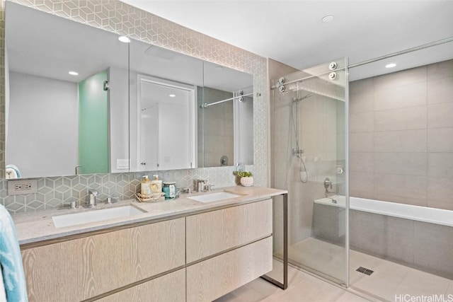 bathroom with decorative backsplash, vanity, tile patterned floors, and tiled shower / bath combo