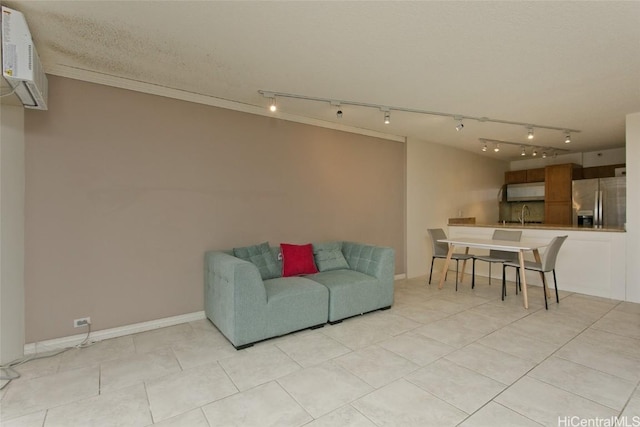 living room with light tile patterned floors, ornamental molding, sink, and a wall mounted air conditioner