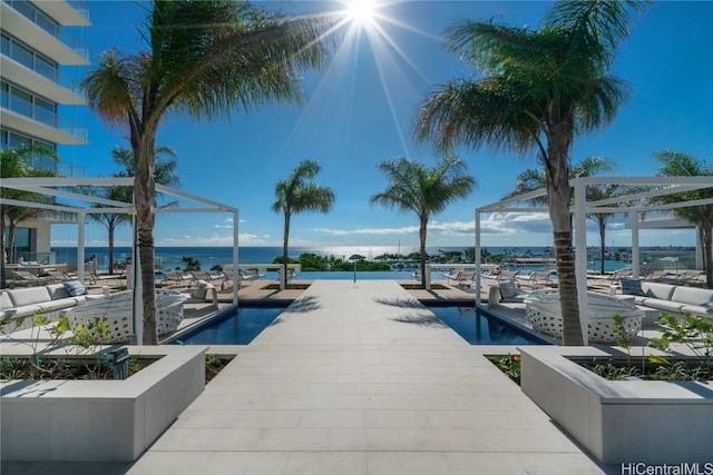 view of pool with a gazebo, a water view, and outdoor lounge area