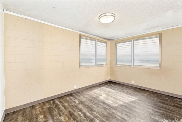 spare room featuring dark hardwood / wood-style flooring and a textured ceiling