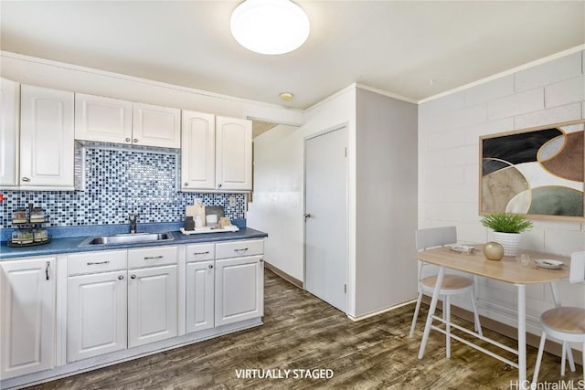 kitchen with white cabinetry, sink, decorative backsplash, and dark wood-type flooring