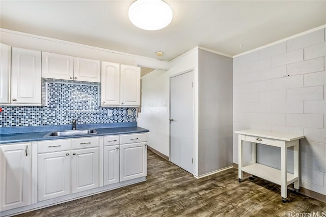 kitchen with dark hardwood / wood-style flooring, sink, decorative backsplash, and white cabinets