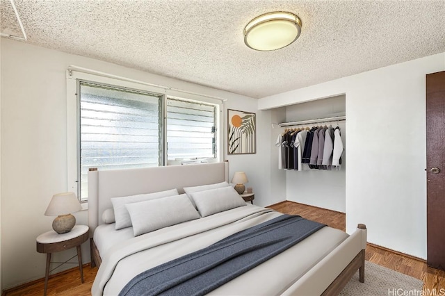 bedroom featuring wood-type flooring, a closet, and a textured ceiling