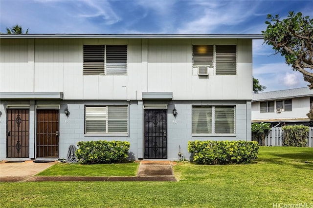 view of property with cooling unit and a front lawn