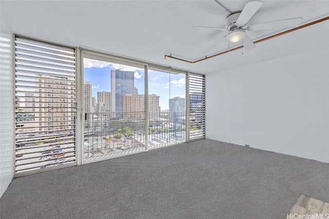 carpeted empty room with a textured ceiling and ceiling fan