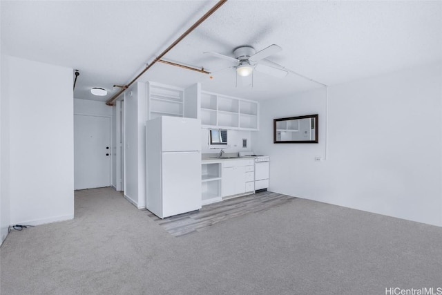 kitchen featuring ceiling fan, sink, white appliances, light carpet, and white cabinets