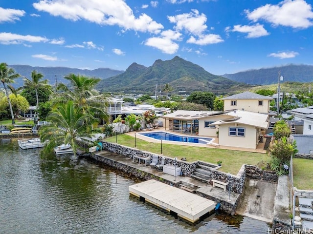 dock area featuring a water and mountain view, a yard, and a patio