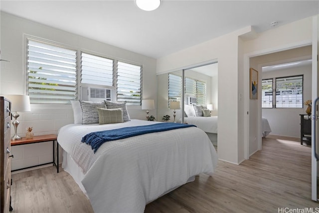 bedroom featuring light hardwood / wood-style flooring and multiple windows