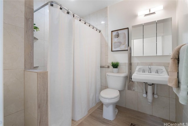 bathroom featuring tile walls, toilet, and a shower with curtain