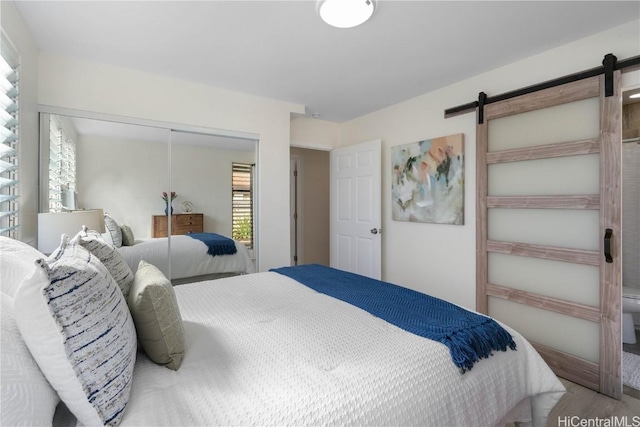 bedroom featuring hardwood / wood-style floors, a closet, and a barn door