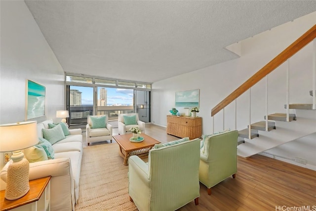 living room featuring a textured ceiling, floor to ceiling windows, and hardwood / wood-style floors