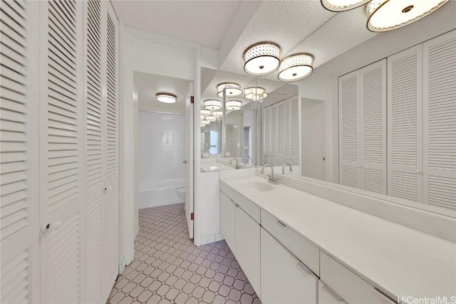 bathroom featuring a textured ceiling, toilet, and vanity