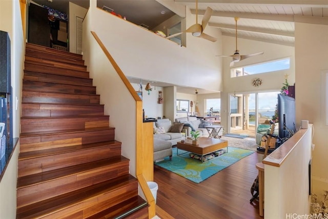 living room with wood ceiling, wood-type flooring, high vaulted ceiling, ceiling fan, and beam ceiling