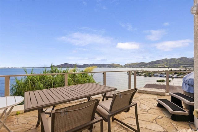 view of patio featuring a balcony and a water and mountain view