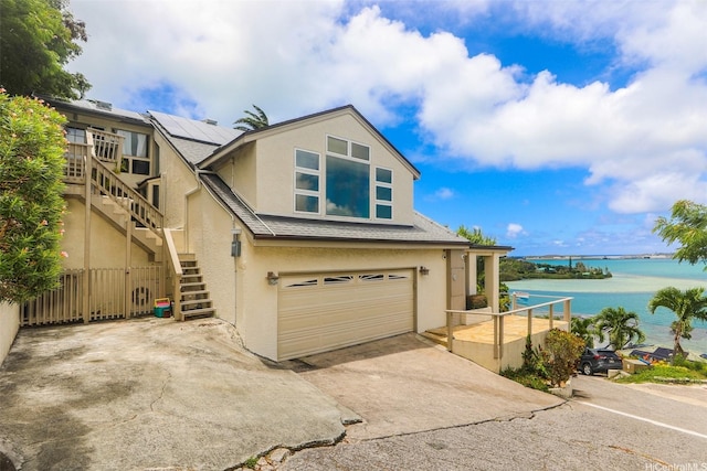 45-001 Lilipuna Rd Unit B, Kaneohe, HI 96744 - view of front of house with stucco siding, stairway, a water view, concrete driveway, and an attached garage
