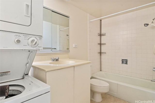 full bathroom with stacked washer / drying machine, vanity, toilet, and tiled shower / bath