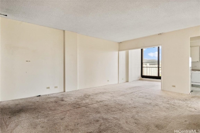 carpeted empty room featuring a textured ceiling