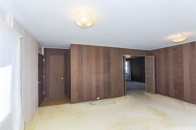 carpeted empty room with wood walls