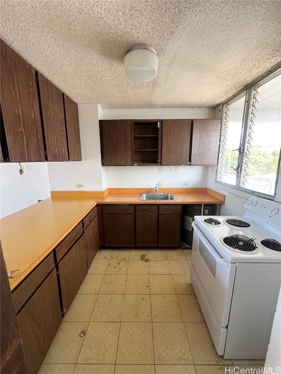 kitchen featuring a textured ceiling, white electric range oven, dark brown cabinetry, sink, and light tile patterned floors