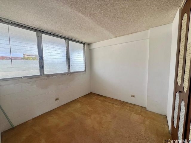 carpeted empty room featuring a textured ceiling