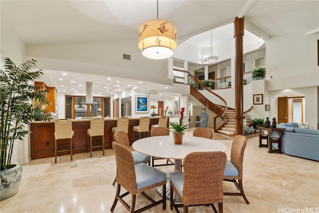 dining room with visible vents, stairway, a towering ceiling, and recessed lighting