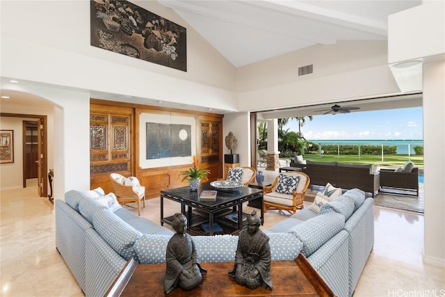 living area featuring visible vents, high vaulted ceiling, beam ceiling, arched walkways, and ceiling fan