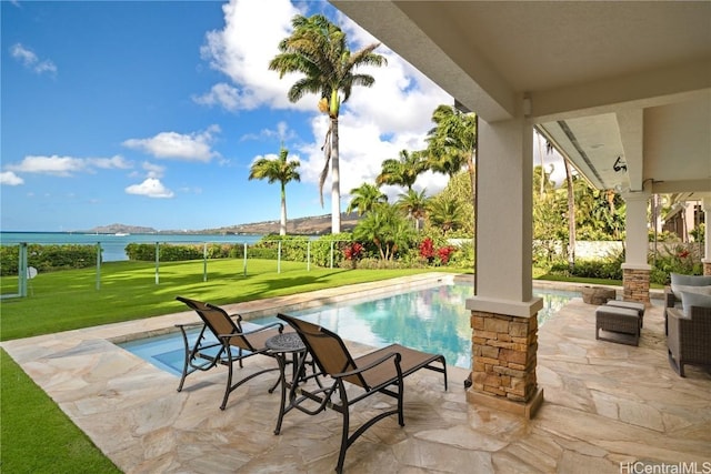 view of pool featuring a fenced in pool, a patio, a lawn, and a water view