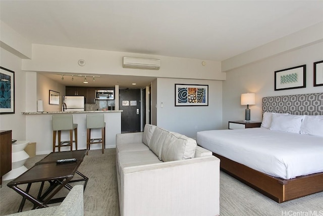 carpeted bedroom with rail lighting, fridge, and a wall unit AC