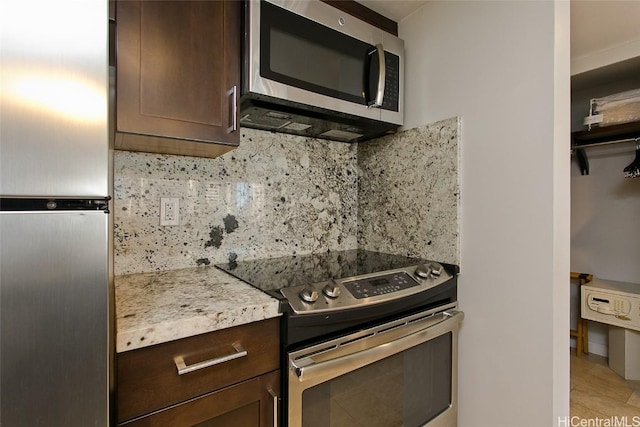 kitchen with stainless steel appliances, dark brown cabinetry, and decorative backsplash