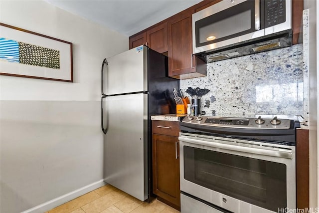 kitchen with light tile patterned floors, tasteful backsplash, baseboards, appliances with stainless steel finishes, and light countertops