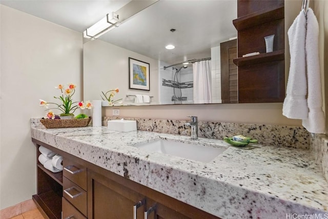 bathroom with curtained shower, vanity, and tile patterned floors