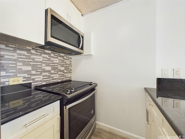 kitchen with appliances with stainless steel finishes, crown molding, and tasteful backsplash