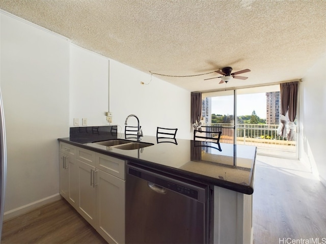 kitchen with white cabinets, dishwasher, sink, and a textured ceiling