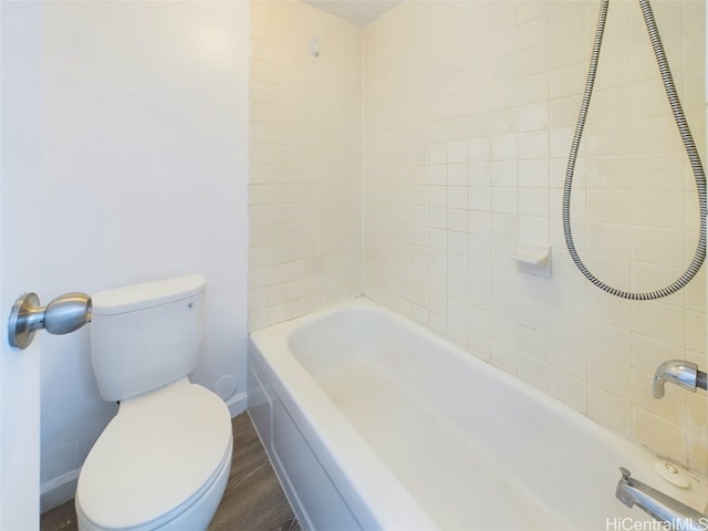 bathroom featuring toilet, tiled shower / bath combo, and hardwood / wood-style flooring