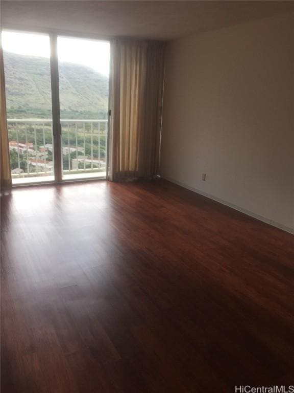 spare room featuring dark hardwood / wood-style floors, plenty of natural light, and a mountain view