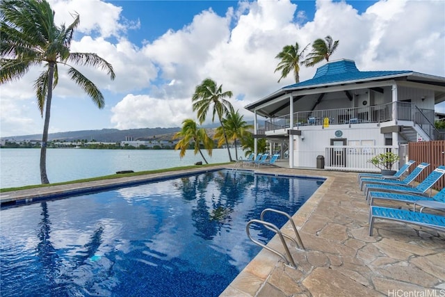 view of swimming pool featuring a water and mountain view and a patio