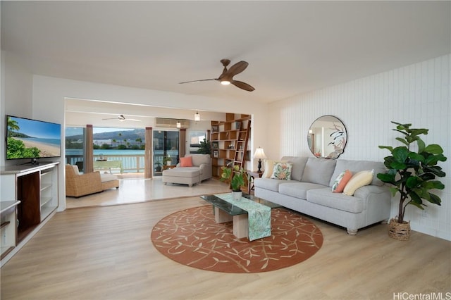 living room with a water view and light hardwood / wood-style flooring